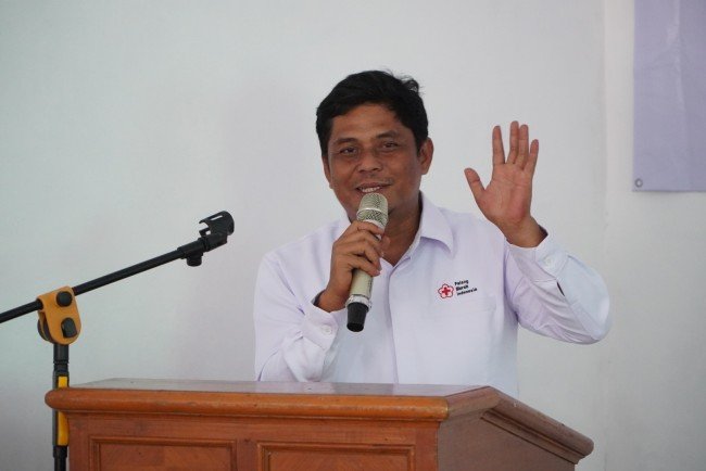 Plt. Ketua PMI Kepulauan Seribu, A. Furqon, menyampaikan laporan penuh canda di pembukaan Muslub 2025, menciptakan suasana akrab dan penuh gelak tawa.